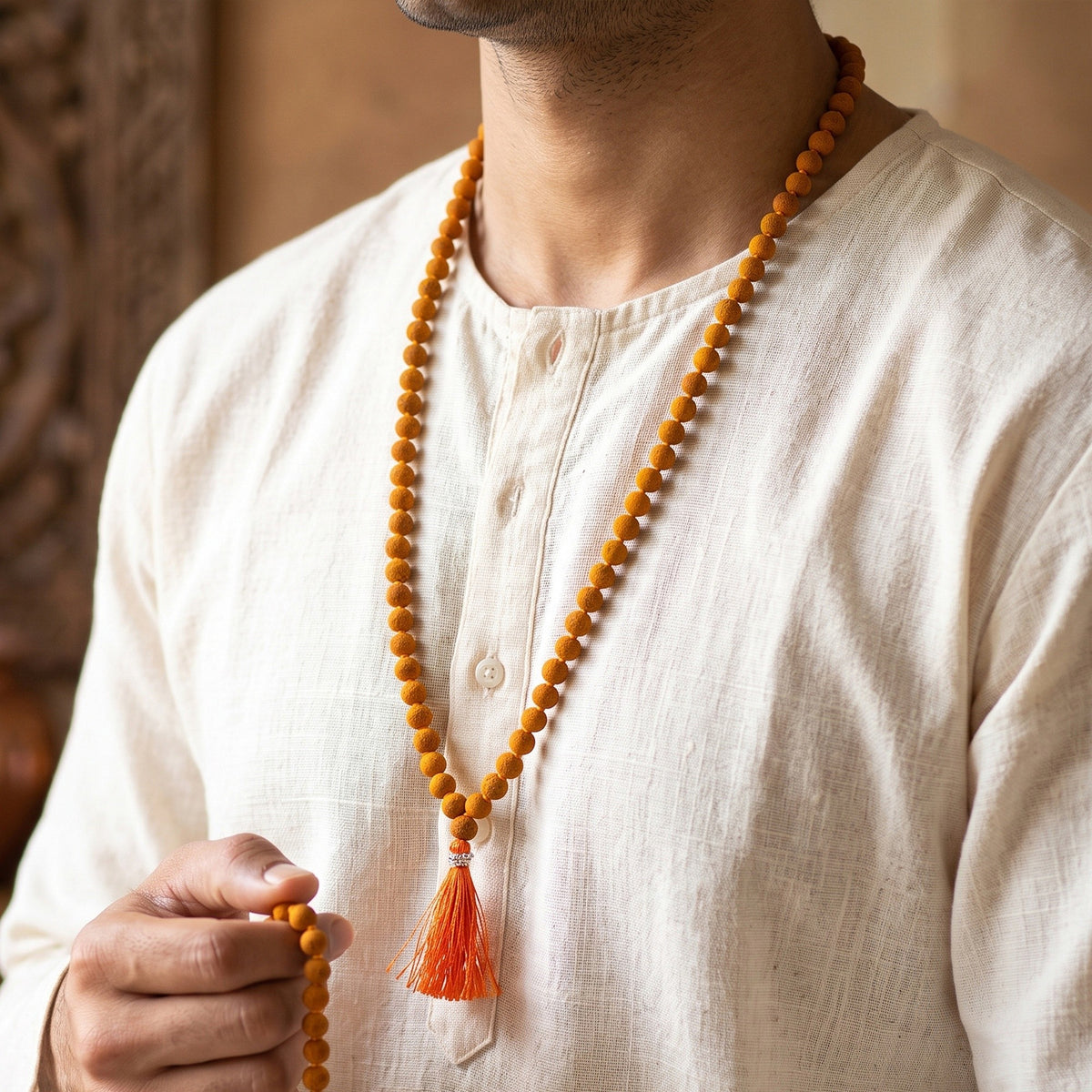 Man wearing the Haldi Jaap Mala and holding the beads for jaap