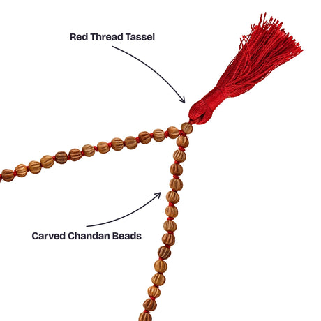 Close-up of the carved sandalwood beads and the red thread tassel