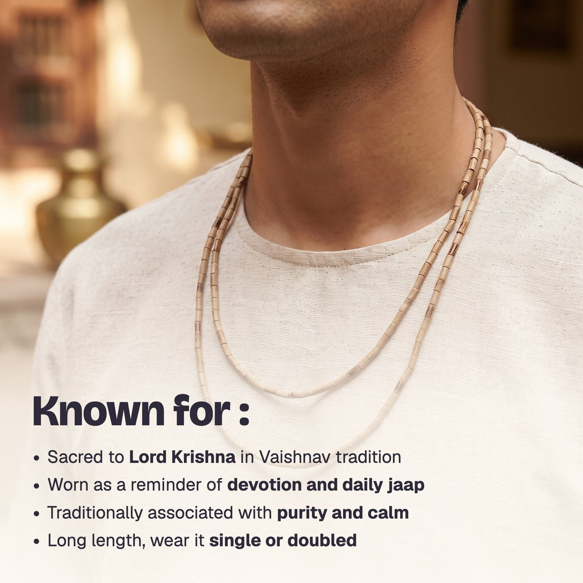 Man wearing the long Tulsi Kanthi Mala doubled over a cream kurta