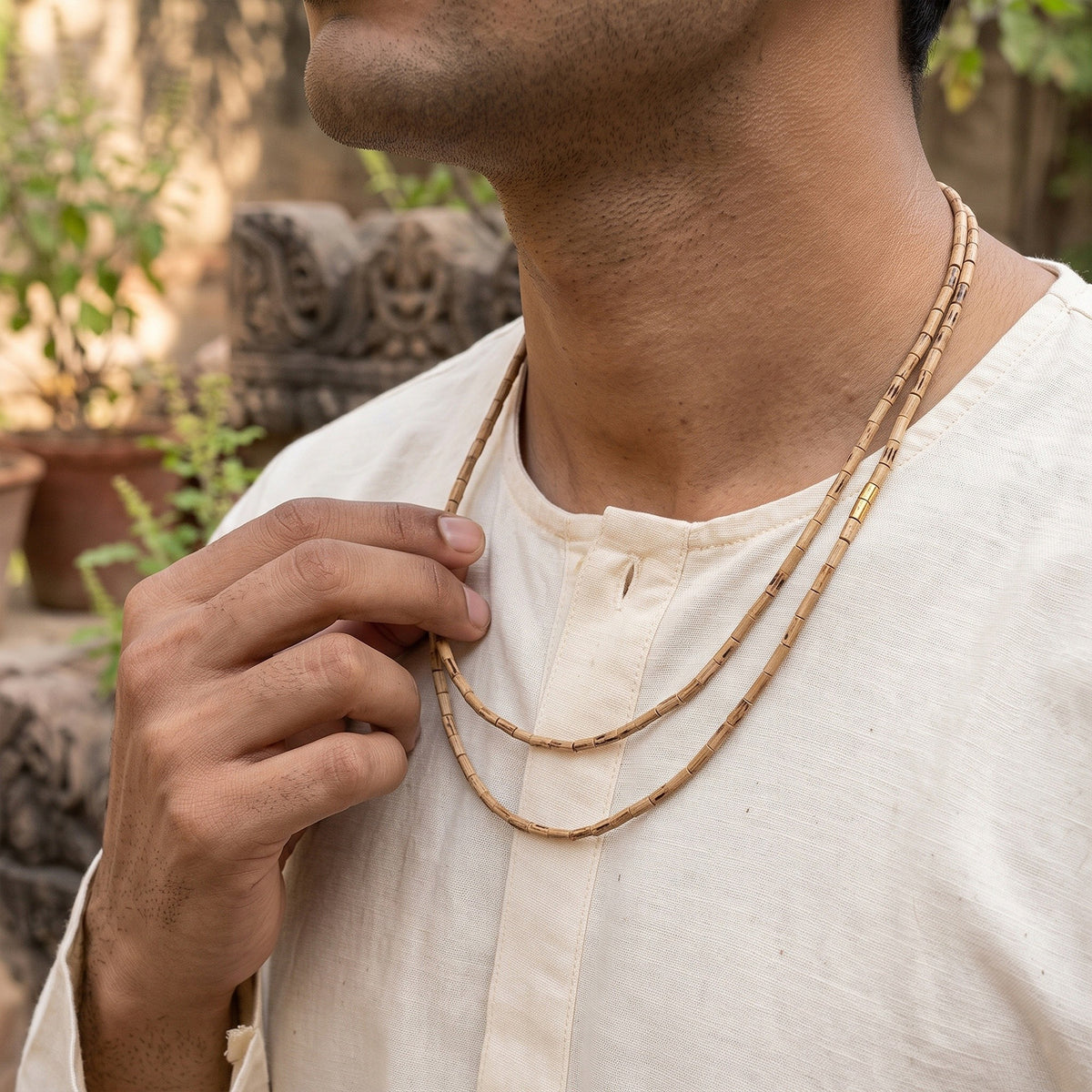 Man holding the elongated-bead Tulsi Kanthi Mala at his chest